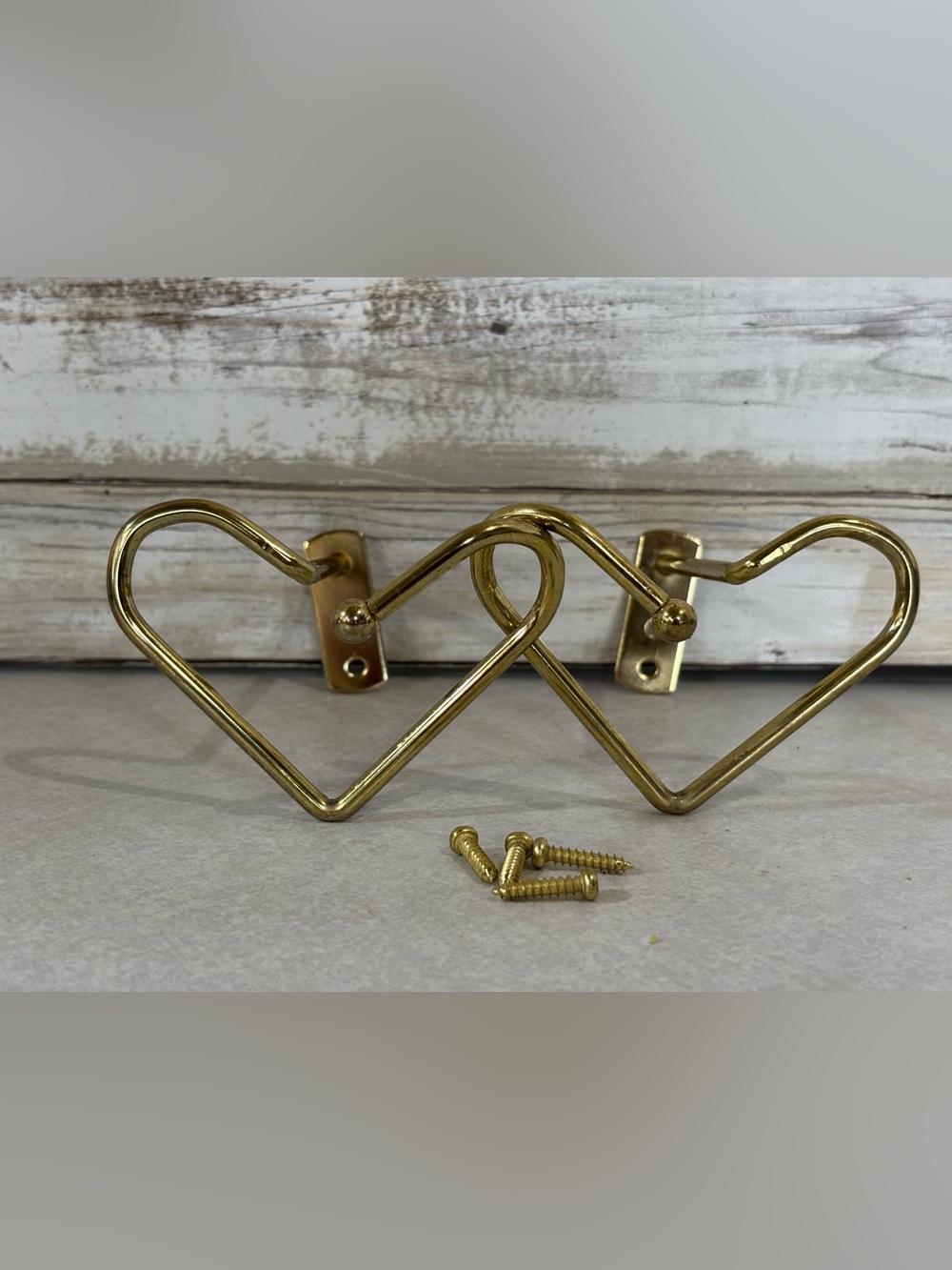 Pair of 2 brass/gold metal coloured curtain tie-backs (heart shape)